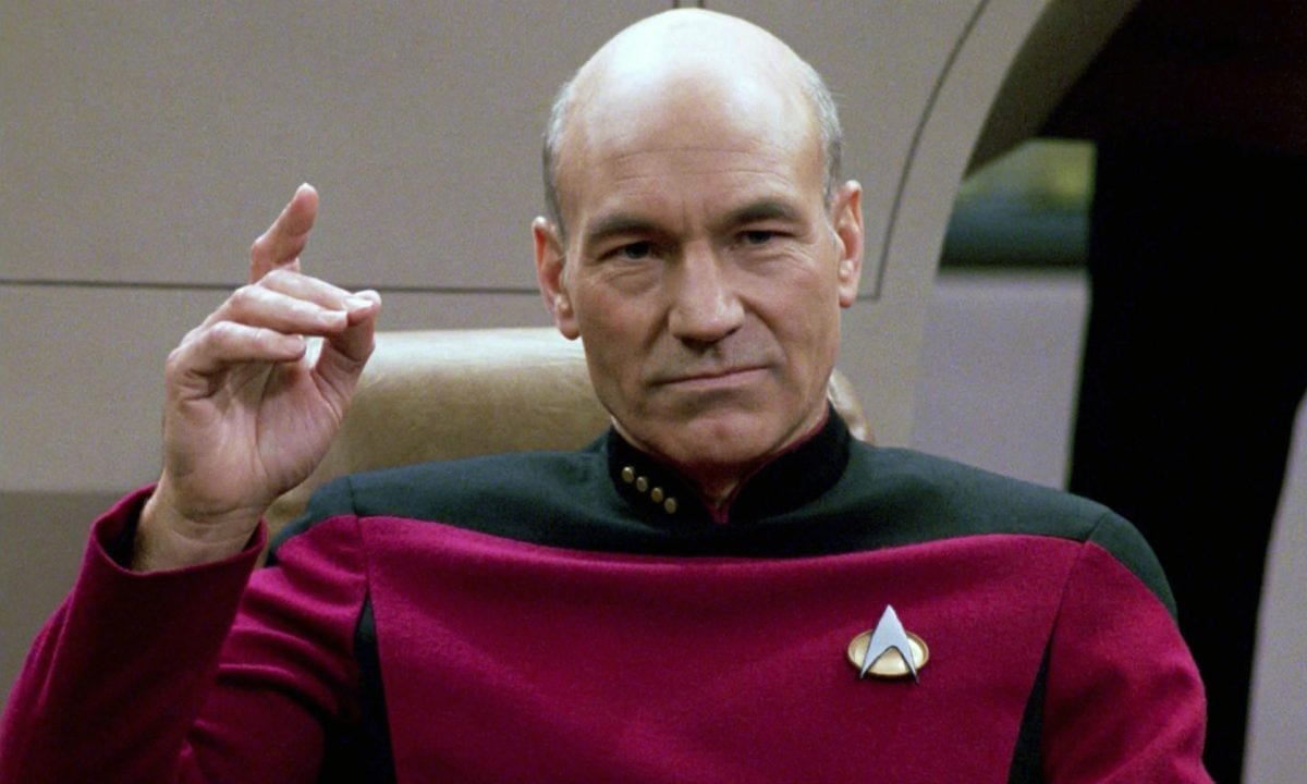 Captain Picard in his captain's chair, gesturing with a pointed finger