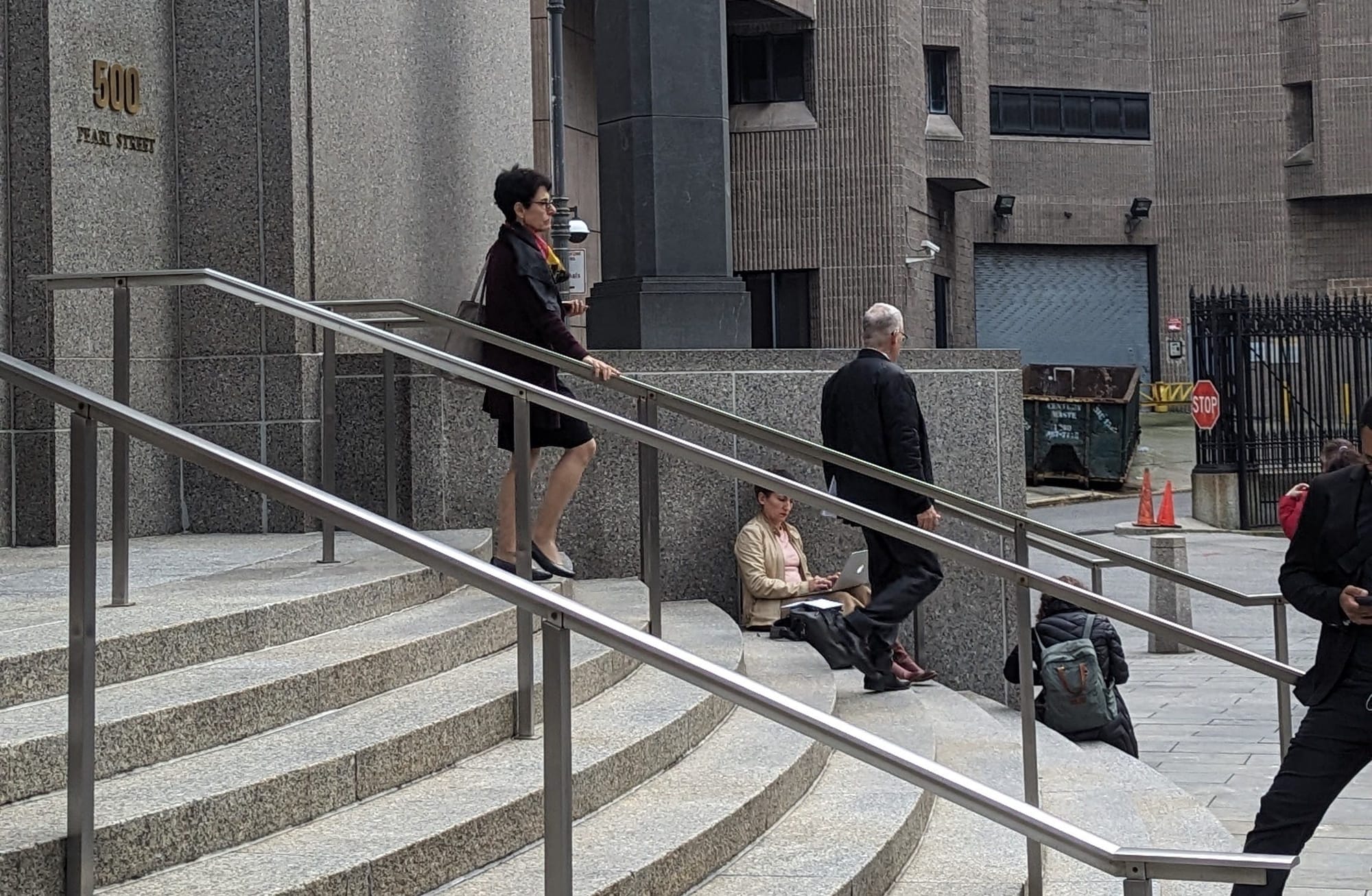 Photograph of Barbara Fried walking down the steps of the 500 Pearl St. courthouse in NYC, following Joseph Bankman.